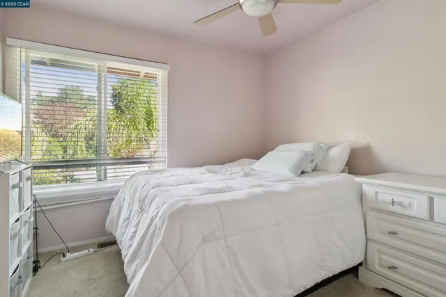 a bedroom with a bed and a large window