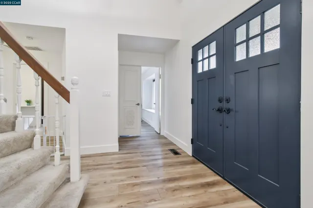 a view of a hallway with wooden floor and staircase