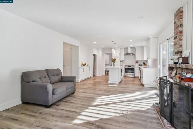 a living room with furniture and a dining table with kitchen view