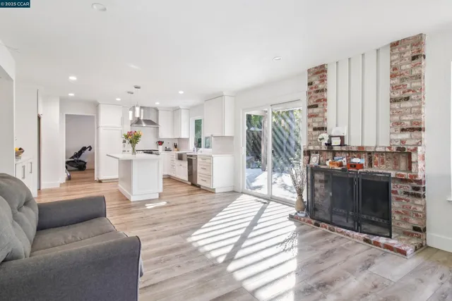 a living room with furniture a fireplace and a kitchen view