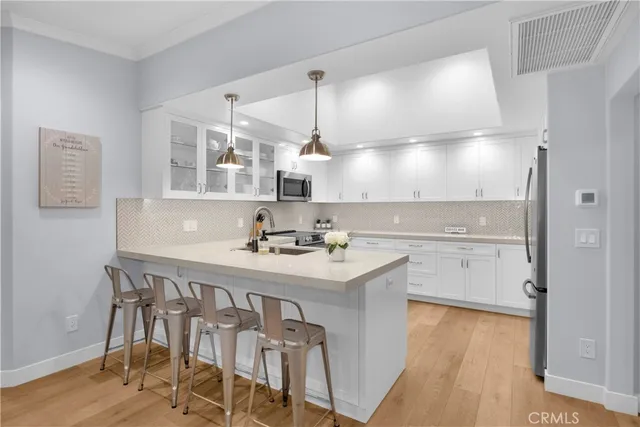 a kitchen with a sink cabinets and wooden floor