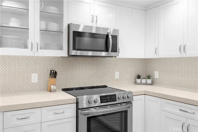 a kitchen with a table a refrigerator and cabinets
