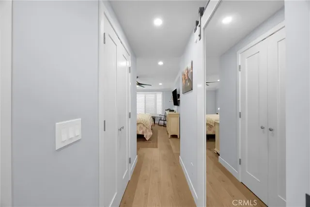 a bedroom with a bed a window and flat screen tv