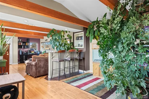 a balcony with table and chairs potted plants