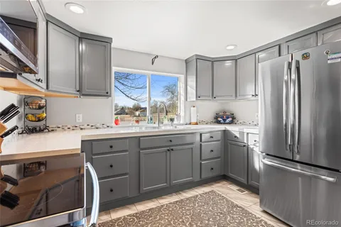 a kitchen with a sink refrigerator and cabinets