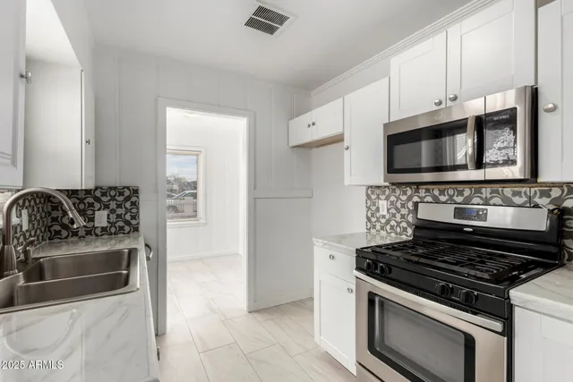a kitchen with granite countertop a stove and a microwave