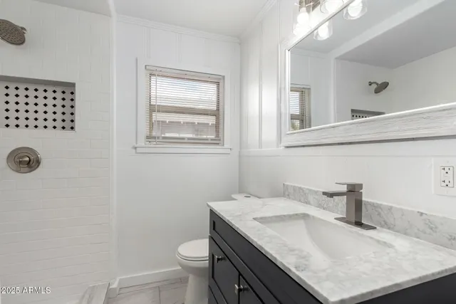 a bathroom with a granite countertop sink toilet and shower