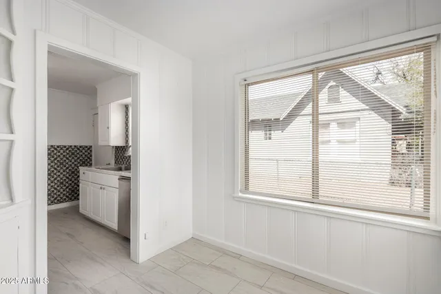 a bathroom with a granite countertop sink and a large mirror next to a window