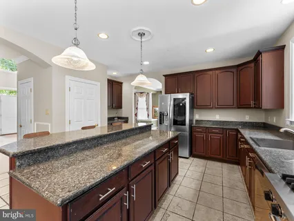 a kitchen with stainless steel appliances granite countertop wooden cabinets a granite counter tops and a stove