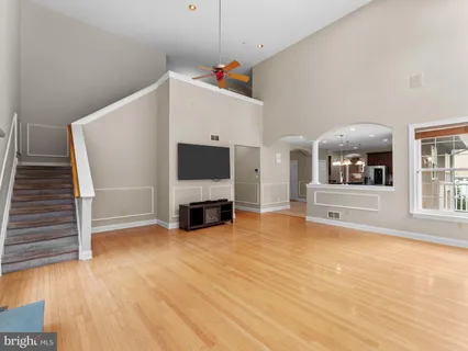 a view of a livingroom with wooden floor and a ceiling fan