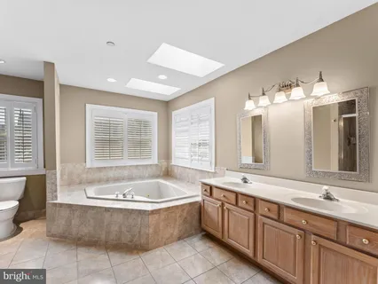 a spacious bathroom with a large tub sink and mirror