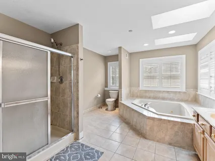 a spacious bathroom with a tub shower and toilet