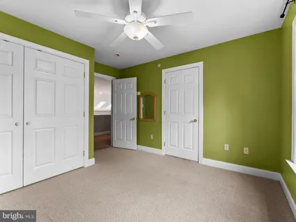 an empty room with a ceiling fan and a window