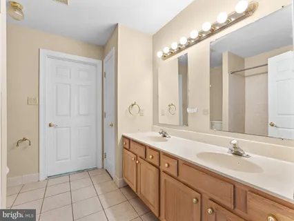 a spacious bathroom with a double vanity sink a mirror and a shower