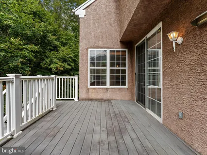 a view of front door deck with wooden floor and fence