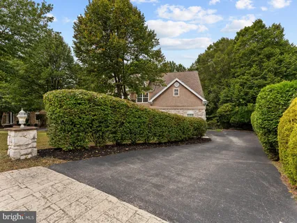a view of a house with a yard and large tree