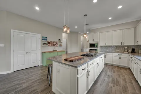 a kitchen with stainless steel appliances kitchen island granite countertop a stove a sink and a refrigerator