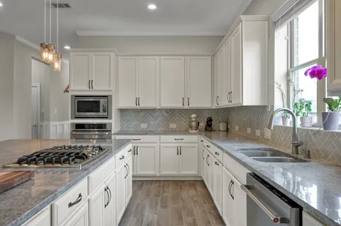 a kitchen with granite countertop a sink stove and refrigerator