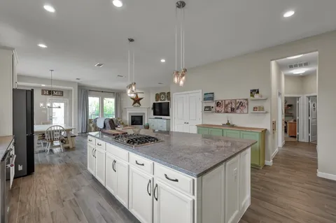 a kitchen with stainless steel appliances granite countertop stove top oven and cabinets