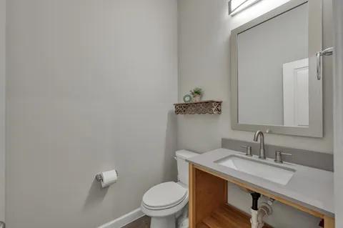 a bathroom with a sink a toilet and a mirror