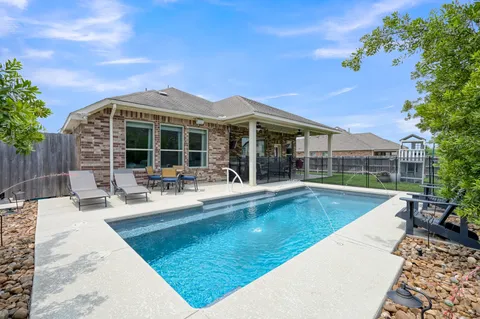 a view of a house with swimming pool and sitting area