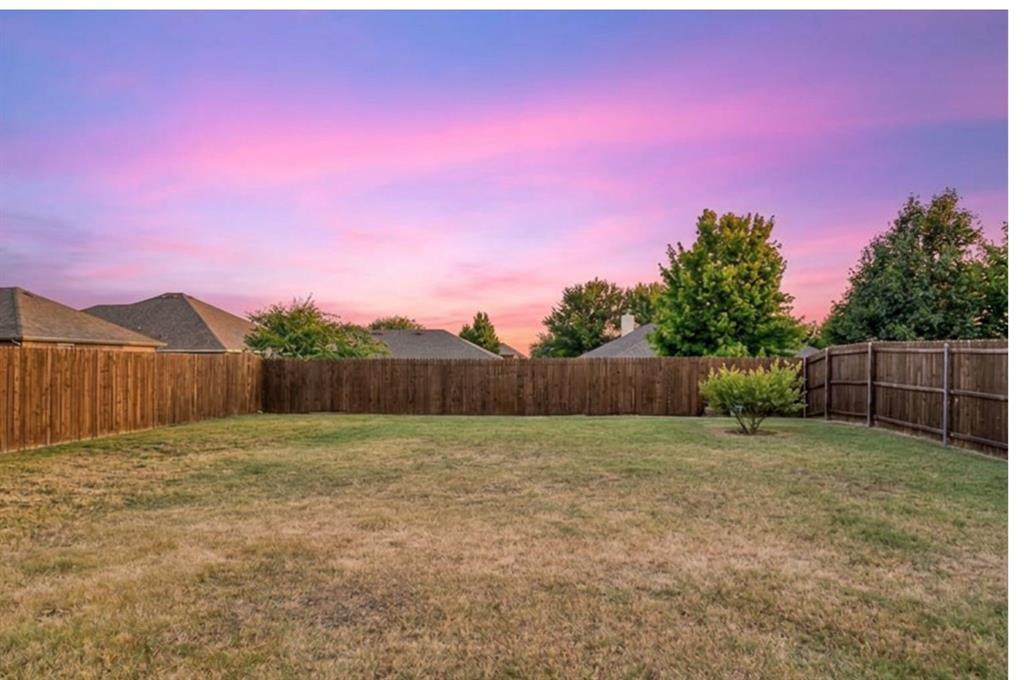 409 Wilson Way Denton, TX 76207 - Photo 25 of 33 Expansive backyard featuring a manicured lawn, established landscaping, and a privacy fence