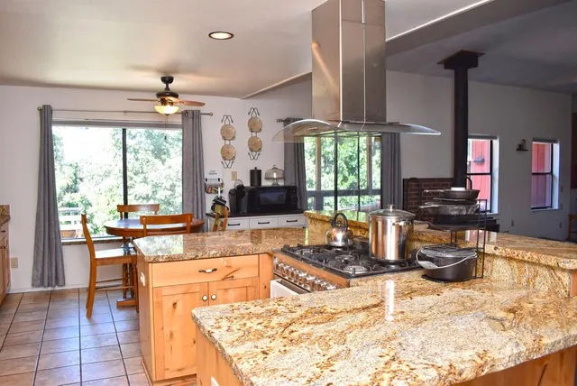 a kitchen with stainless steel appliances granite countertop a sink window and cabinets