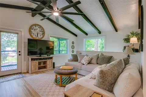 a living room with furniture a flat screen tv and a window