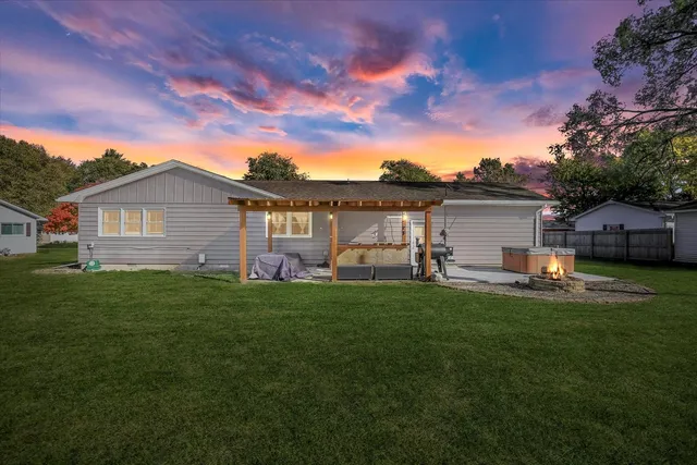a front view of house with yard and trees in the background