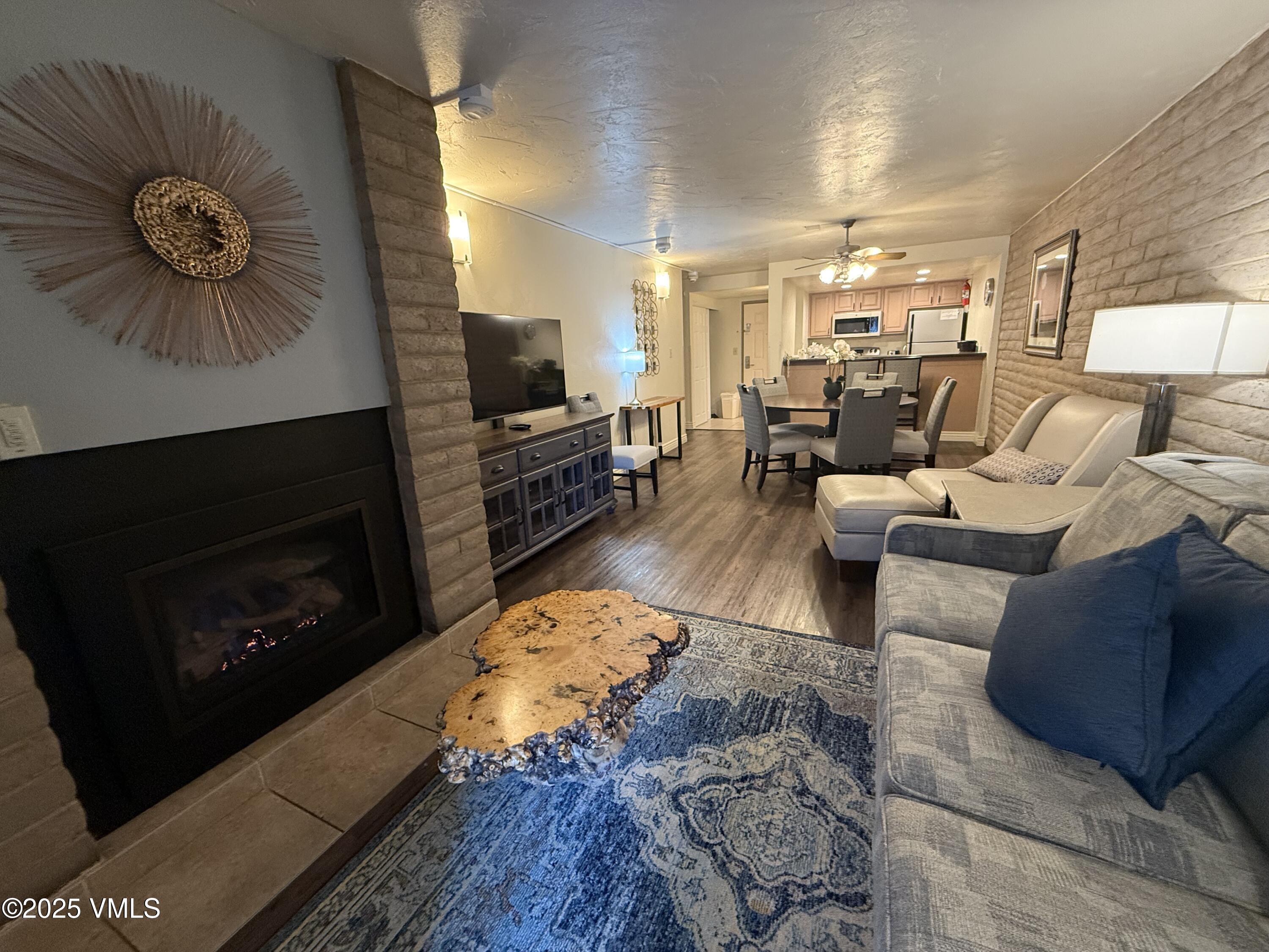 1020 Vail View Drive, Unit 220139 Vail, CO 81657 - Photo 5 of 23 a living room with furniture a flat screen tv and a fireplace