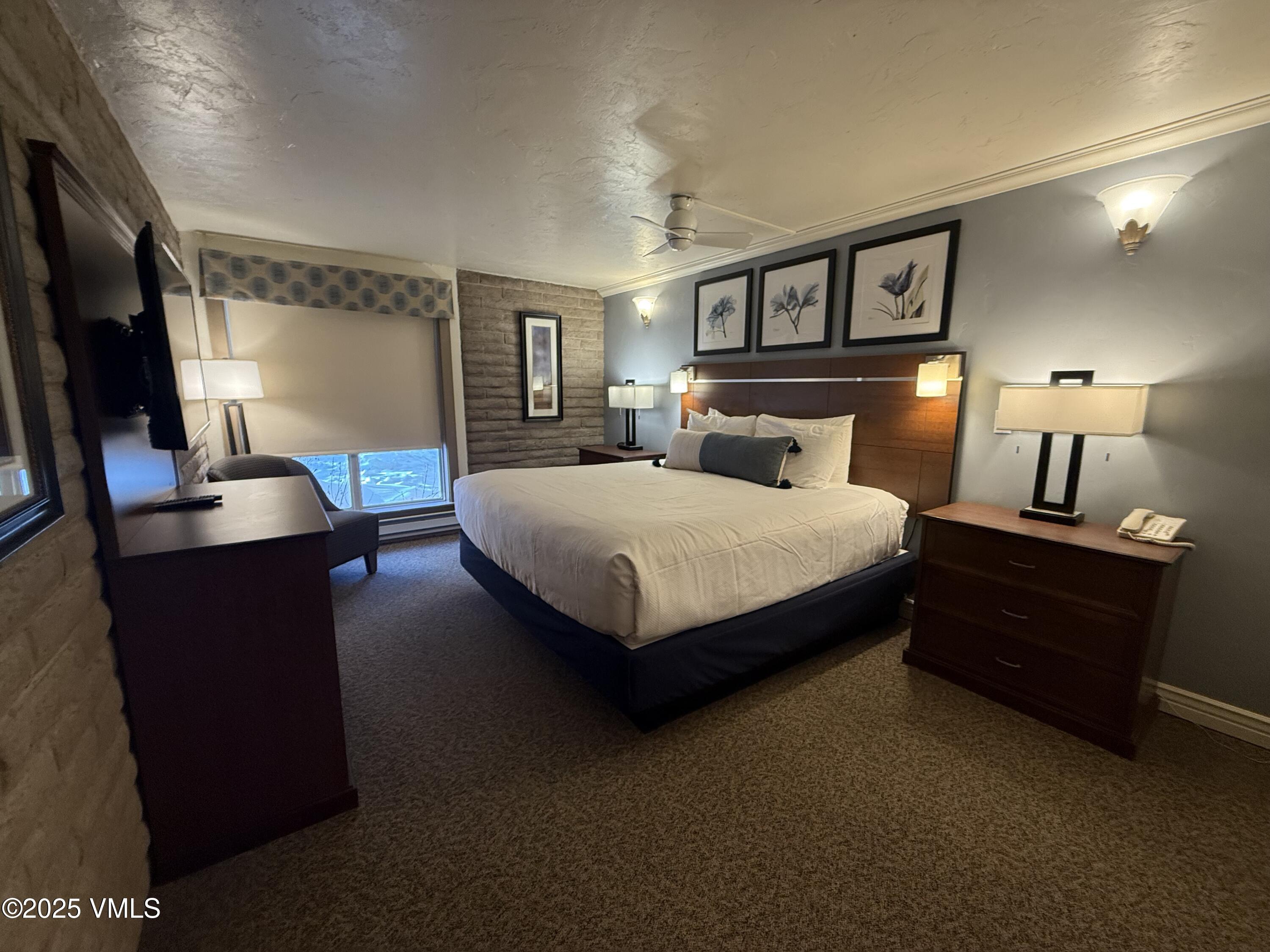 1020 Vail View Drive, Unit 220139 Vail, CO 81657 - Photo 6 of 23 a bedroom with a bed lamps and a large mirror on the dresser