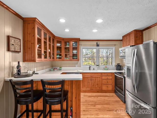 a kitchen with stainless steel appliances granite countertop a sink and a refrigerator