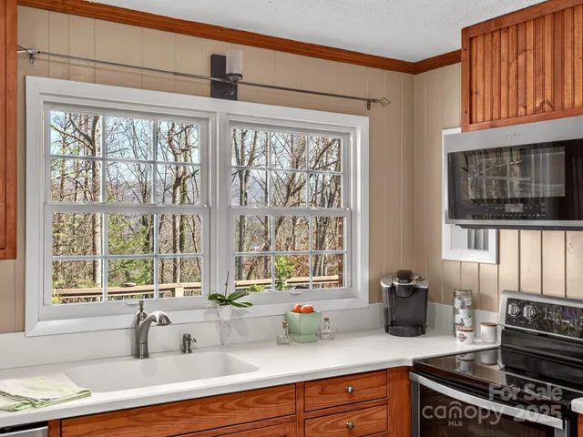 a kitchen with sink a oven and a window