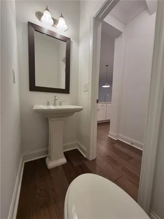 a bathroom with a toilet a sink and mirror