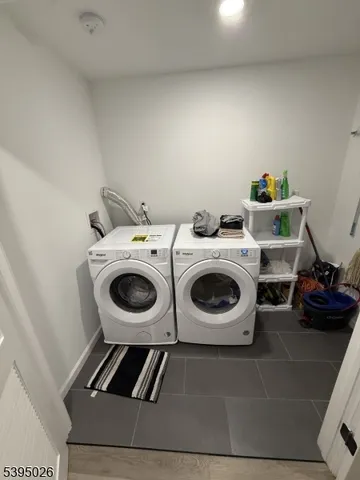 a utility room with dryer washer and a view of living room