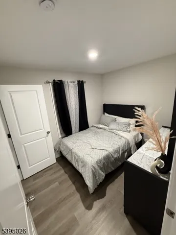 a bedroom with a bed and a refrigerator