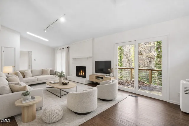 a living room with furniture a fireplace and a flat screen tv