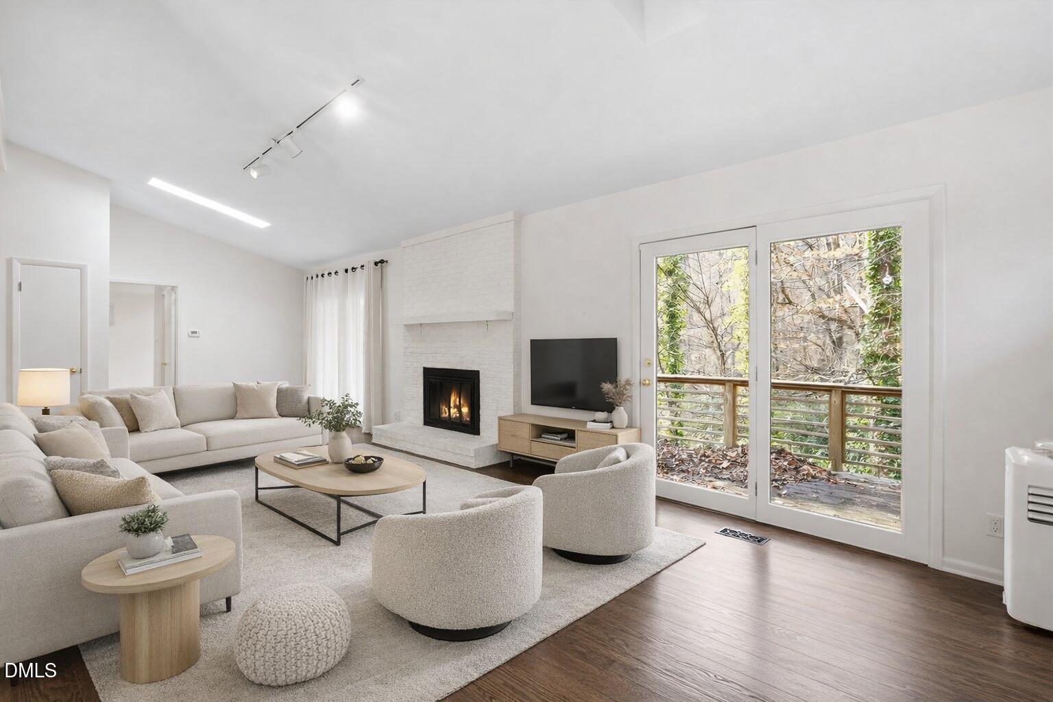 a living room with furniture a fireplace and a flat screen tv
