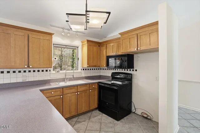 a kitchen with stainless steel appliances a stove a sink and a microwave