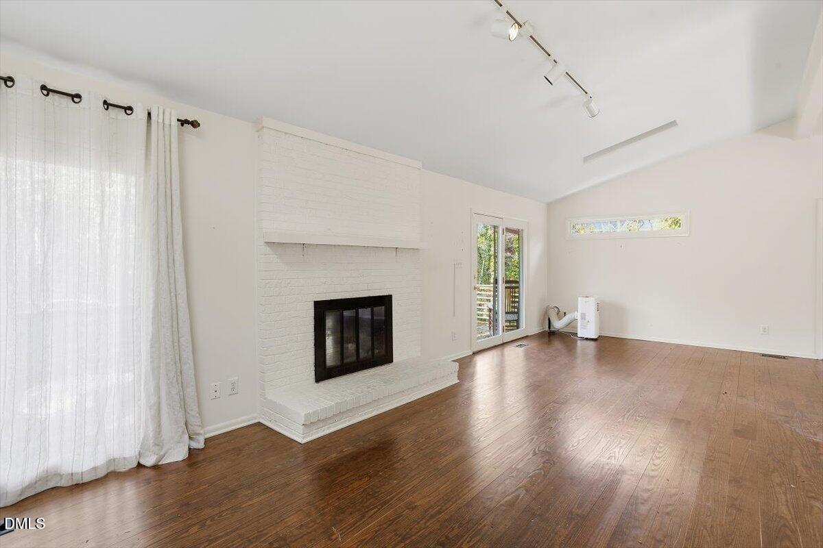 620 Sugarberry Road Chapel Hill, NC 27514 - Photo 12 of 33 a view of an empty room with wooden floor fireplace and a window