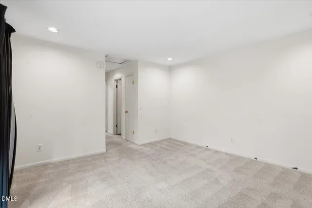 an empty room with windows and fireplace