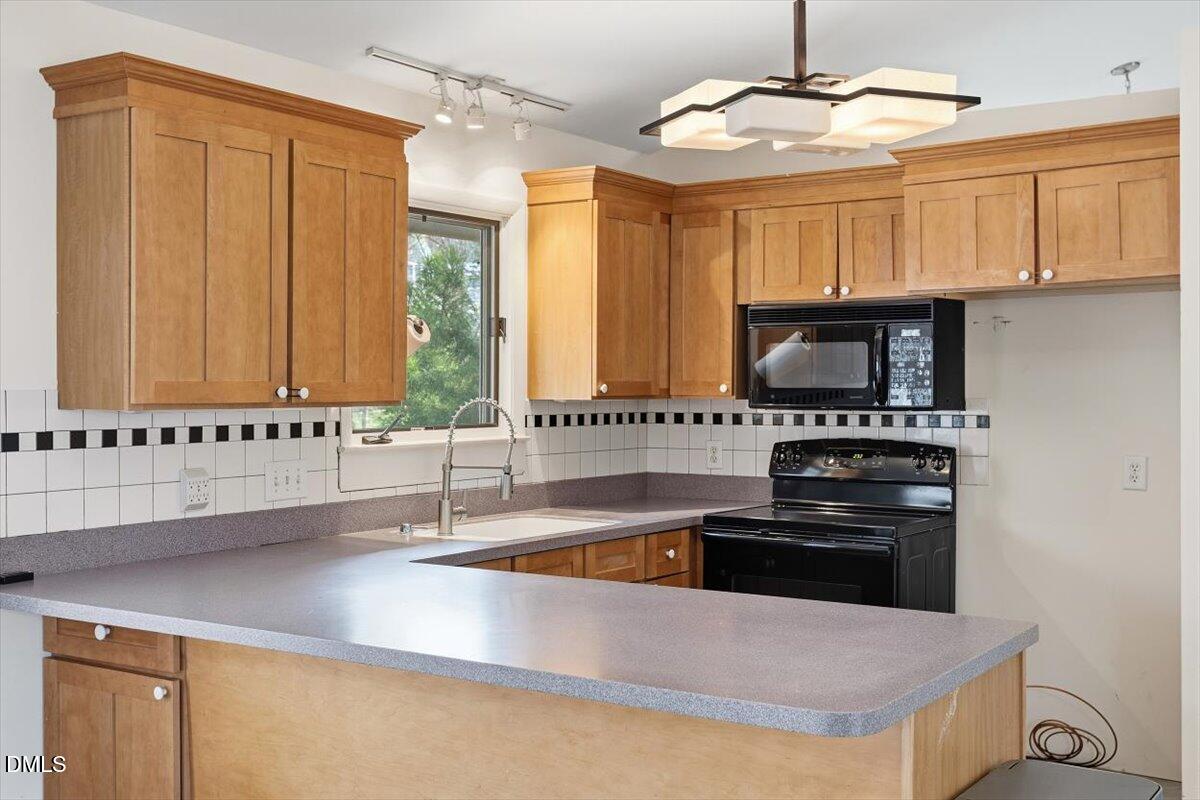 620 Sugarberry Road Chapel Hill, NC 27514 - Photo 18 of 33 a kitchen with stainless steel appliances a stove a sink and a microwave