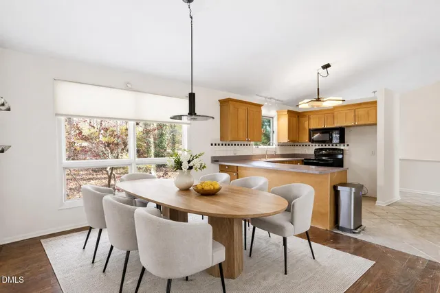 a kitchen with a table chairs sink and cabinets