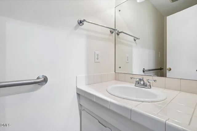 a view of an empty room with wooden floor fireplace and a window