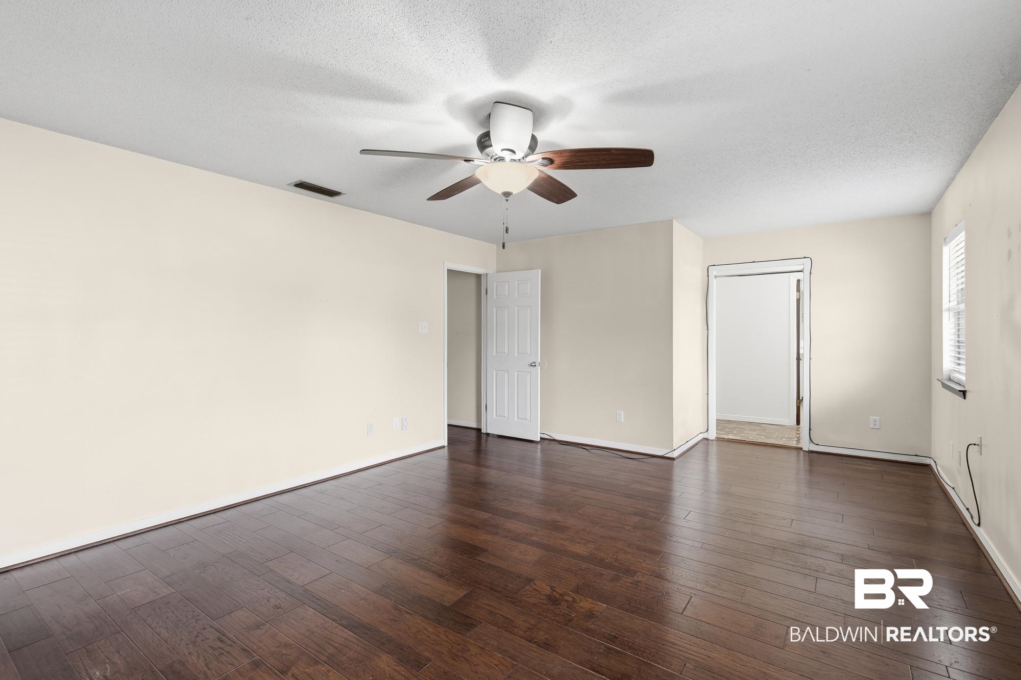 9215 Shiloh Drive Mobile, AL 36695 - Photo 18 of 32 Empty room with dark wood-style floors, a textured ceiling, and a ceiling fan