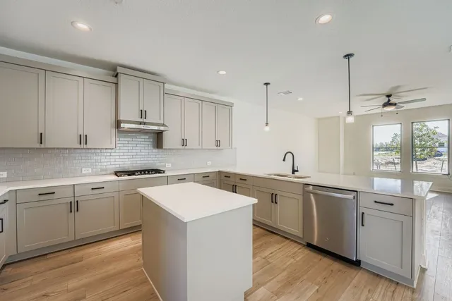 a kitchen with a sink stove and cabinets