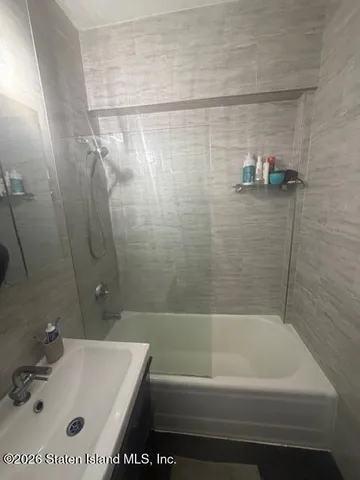 a bathroom with a tub a sink and a shower