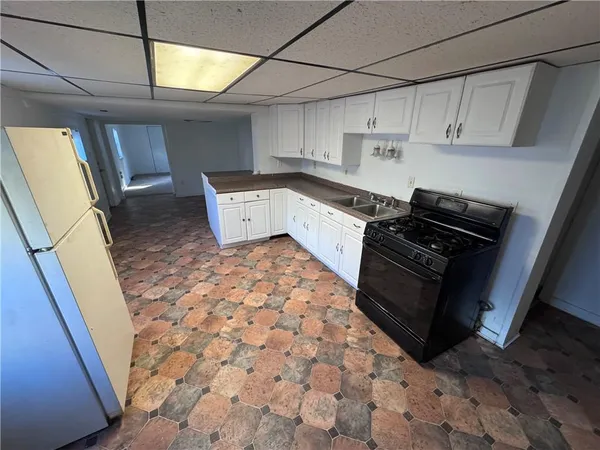 a kitchen with granite countertop a stove a sink and a refrigerator
