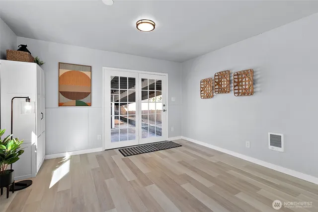 an empty room with wooden floor and windows