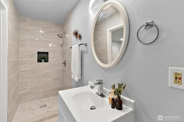 a bathroom with a sink a mirror and a shower